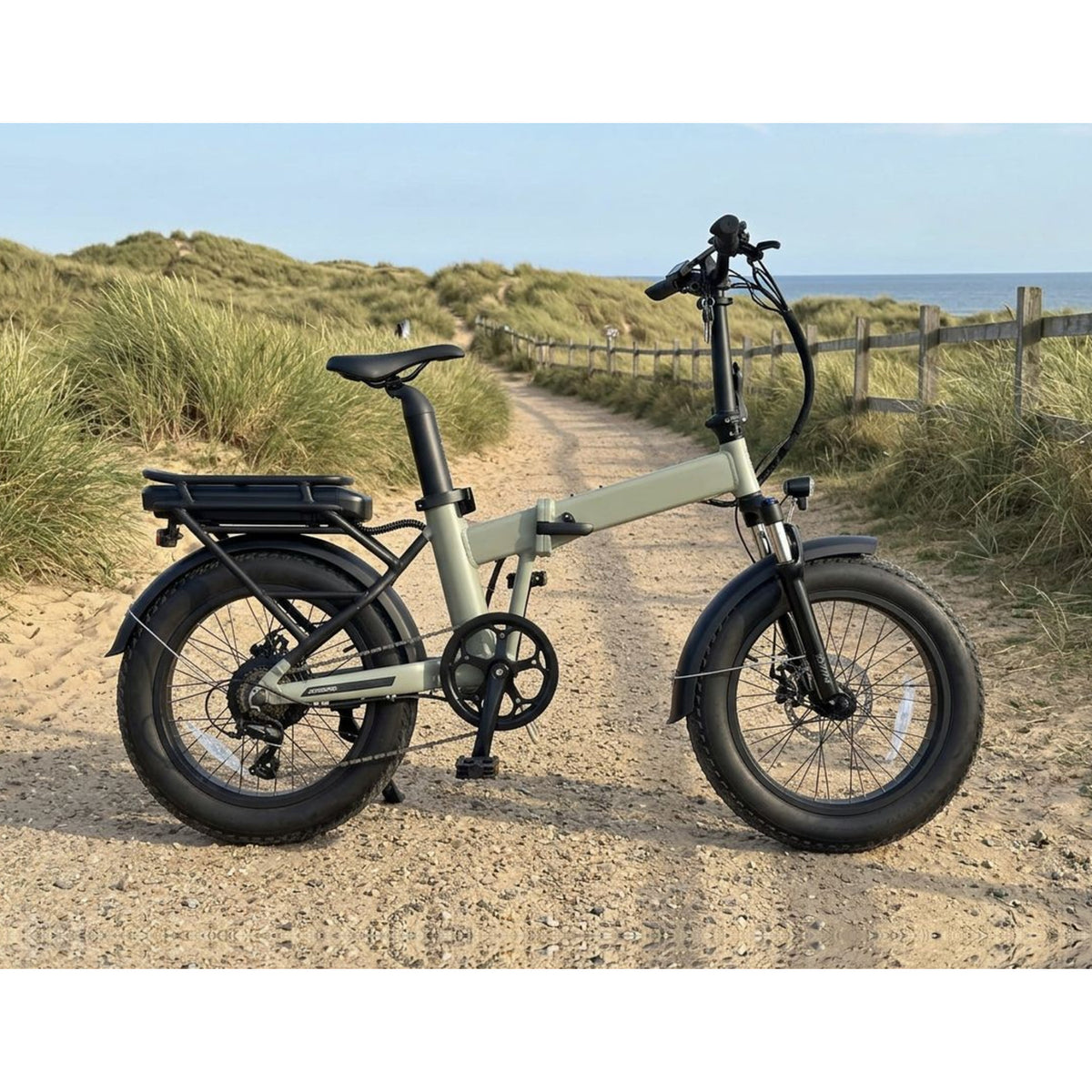 EMU Fat Tyre folding bike on a sandy dune path with the sea behind